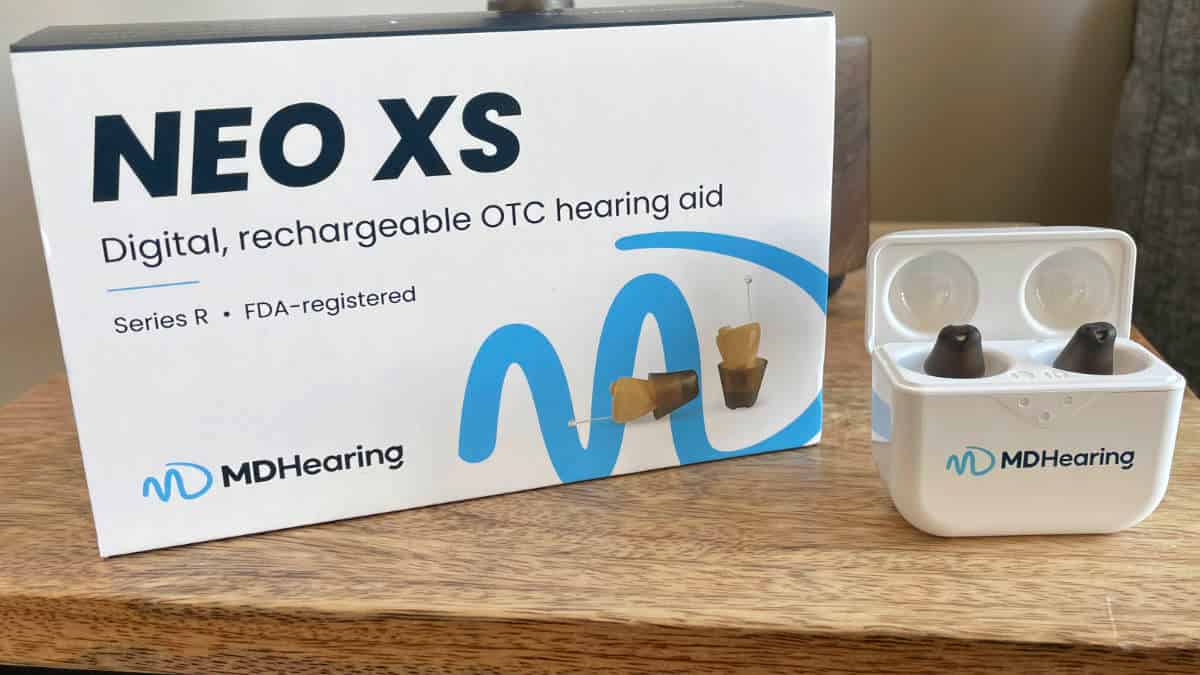 MDHearing Neo XS in-ear OTC hearing aids with charger and packaging.