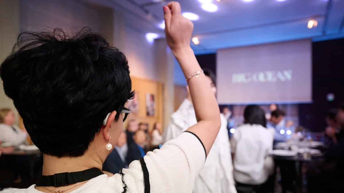 With Auracast, each listener controls the volume. An audience member dances to K-pop music broadcast to attendees wearing Auracast-enabled headphones and hearing aids.