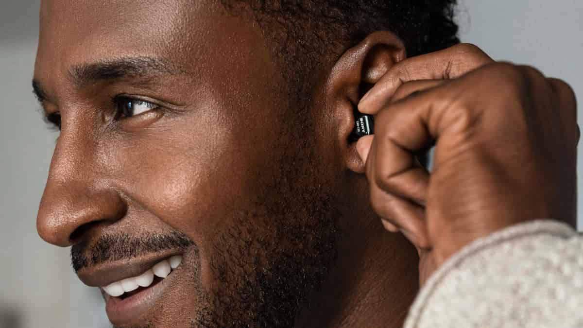 Man inserting a tiny Sony CRE-C20 hearing aid in ear